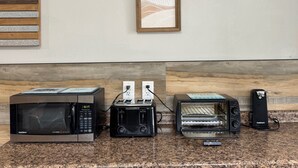 A kitchen with a microwave, toaster, and toaster oven on a granite countertop. - THE INN- PITTSBURGH (Pittsburgh)