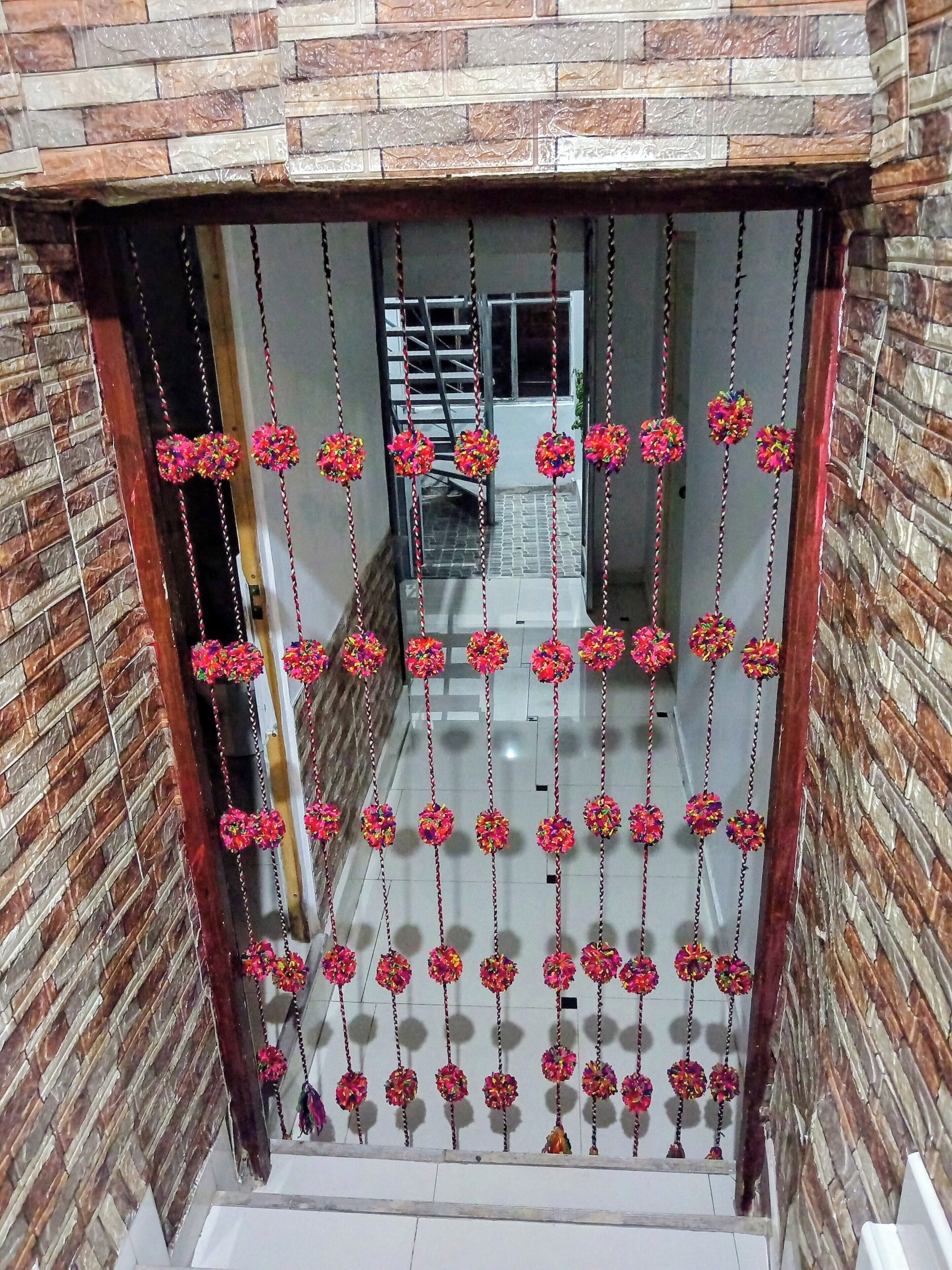 A view through a glass door with a brick wall on one side and a staircase leading to an upper level.