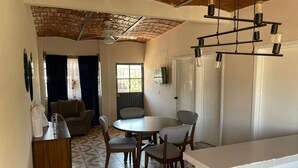 Un espacio habitable compacto con comedor, kitchenette y ventilador de techo.