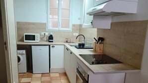 Una cocina compacta con microondas, fregadero y horno.