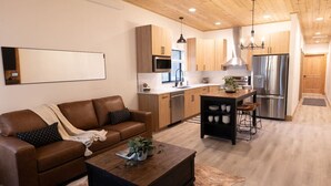 Une cuisine moderne avec des meubles en bois, des appareils en acier inoxydable et un îlot central.