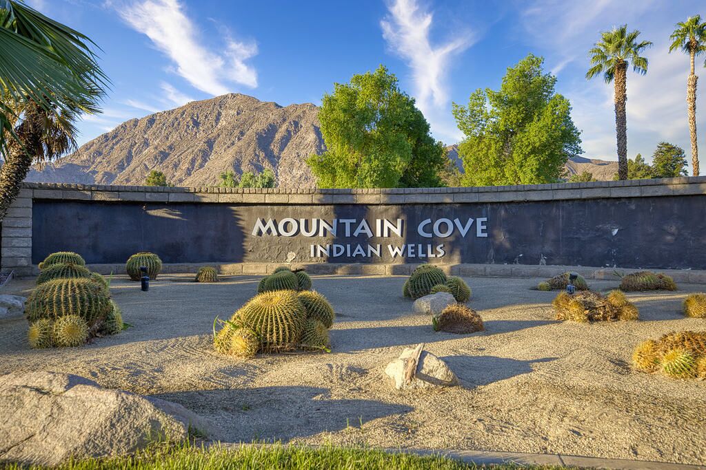 A desert landscape with cacti and palm trees, labeled "Mountain Cove Indian Wells".