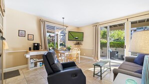 A modern living room with a sofa, a coffee table, and a dining area with chairs and a table. - Condo paradise in Indian Wells. (Indian Wells)