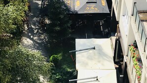 Un bar en la azotea con sombrillas y un pequeño jardín.