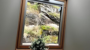 Una finestra a lucernario con vista su un paesaggio roccioso.