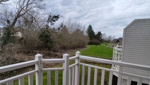 A view from a balcony with a white railing, overlooking a green lawn and a row of houses. - Appartement Belle Dune 2 Chambres (Fort-Mahon-Plage)