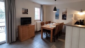 A compact living space with a dining area, a kitchenette, and a television. - Appartement Belle Dune 2 Chambres (Fort-Mahon-Plage)