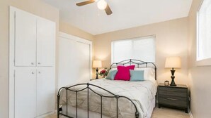 A bedroom with a bed, bedside tables, a wardrobe, and a ceiling fan. - Lovely top floor corner apt in trendy SugarHouse (Salt Lake City)