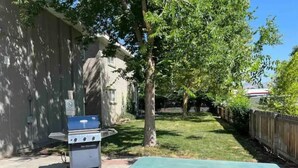 A patio area with a barbecue grill, a picnic table, and a brick pathway. - Lovely top floor corner apt in trendy SugarHouse (Salt Lake City)