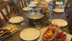 Une table à manger dressée avec des assiettes, des verres et divers aliments.