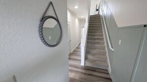 Ein Flur mit einer Treppe, die zu einer Zwischenebene führt.