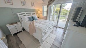 Ein Schlafzimmer mit einem Bett, einem Nachttisch und einem Fernseher.
