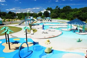 A water park with multiple pools, slides, and lounge areas. - Newly Renovated Bermuda Bay Townhome (Kill Devil Hills)