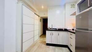 A kitchen with a refrigerator, cabinets, and a countertop.