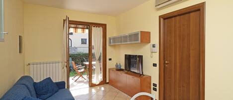 A compact living space with a sofa, dining table, and TV.