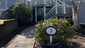 A residential area with a house number 3 sign, a covered walkway, and a tree. - Cozy newly renovated condo, in Norwich, CT. 3 mins from Mohegan Sun Casino. (Norwich)