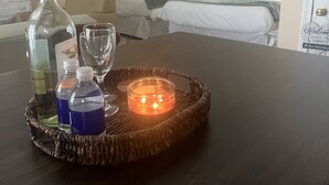 A room with a bed, a bedside table with a candle, and a bottle of water. - Cozy newly renovated condo, in Norwich, CT. 3 mins from Mohegan Sun Casino. (Norwich)