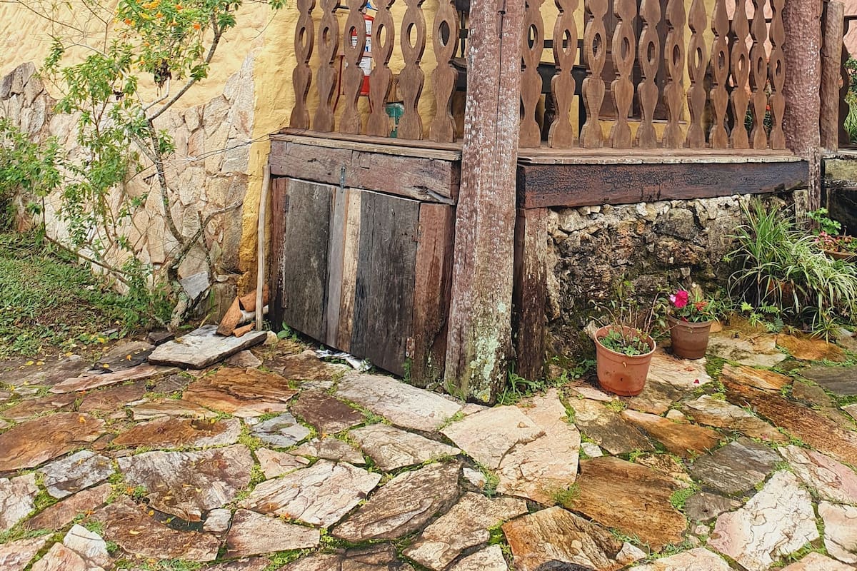 Ein rustikales Gebäude mit einem steingepflasterten Innenhof, Holz-Balkonläufungen und einem traditionellen Ziegeldach.