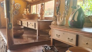 Un interior rústico con vigas de madera, una pared de piedra y una encimera de madera con varios objetos decorativos.