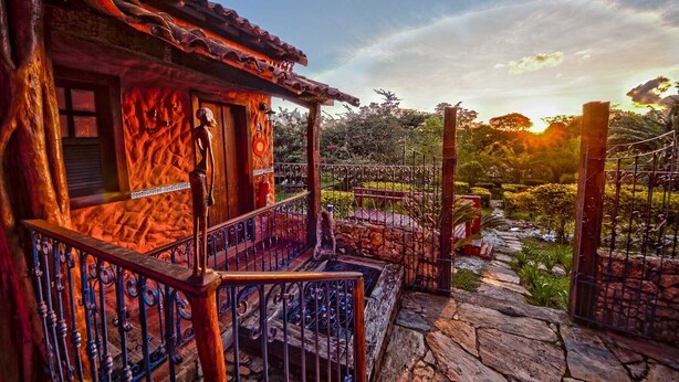 Una casa rústica con una escalera de piedra que lleva a un porche de madera.