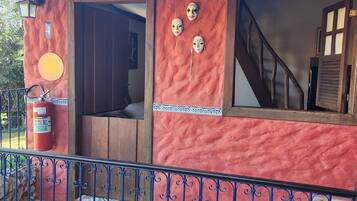 A building with a red exterior, a wooden door, and a staircase leading inside.