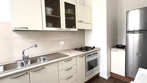 A kitchen with a stainless steel refrigerator, a gas stove, a double sink, and light-colored cabinets. - A34 - Ancona, delightful two-room apartment in the centre (Ancona)