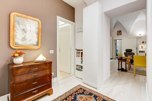A modern living room with a wooden dresser, a marble-framed picture, and a patterned rug.