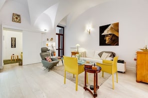 A modern living room with a sofa, yellow chairs, a coffee table, and a fireplace.
