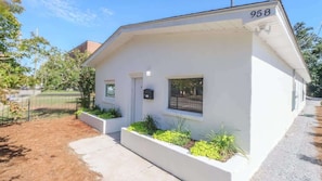 A single-story house with a white exterior, number 958, a front door, a small window, and a mailbox. - Charming 2 Bedroom, 1 Bath Duplex Just Blocks From the Beautiful Beachfront (Biloxi)