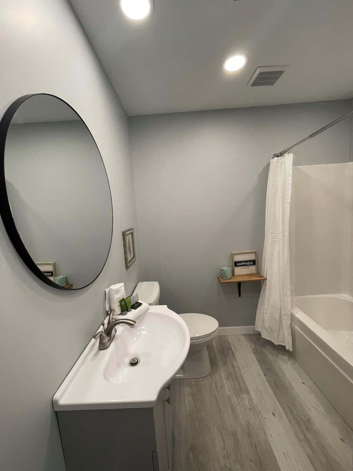 Een moderne badkamer met een wastafel, toilet en bad.