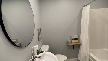 Een moderne badkamer met een wastafel, toilet en bad.