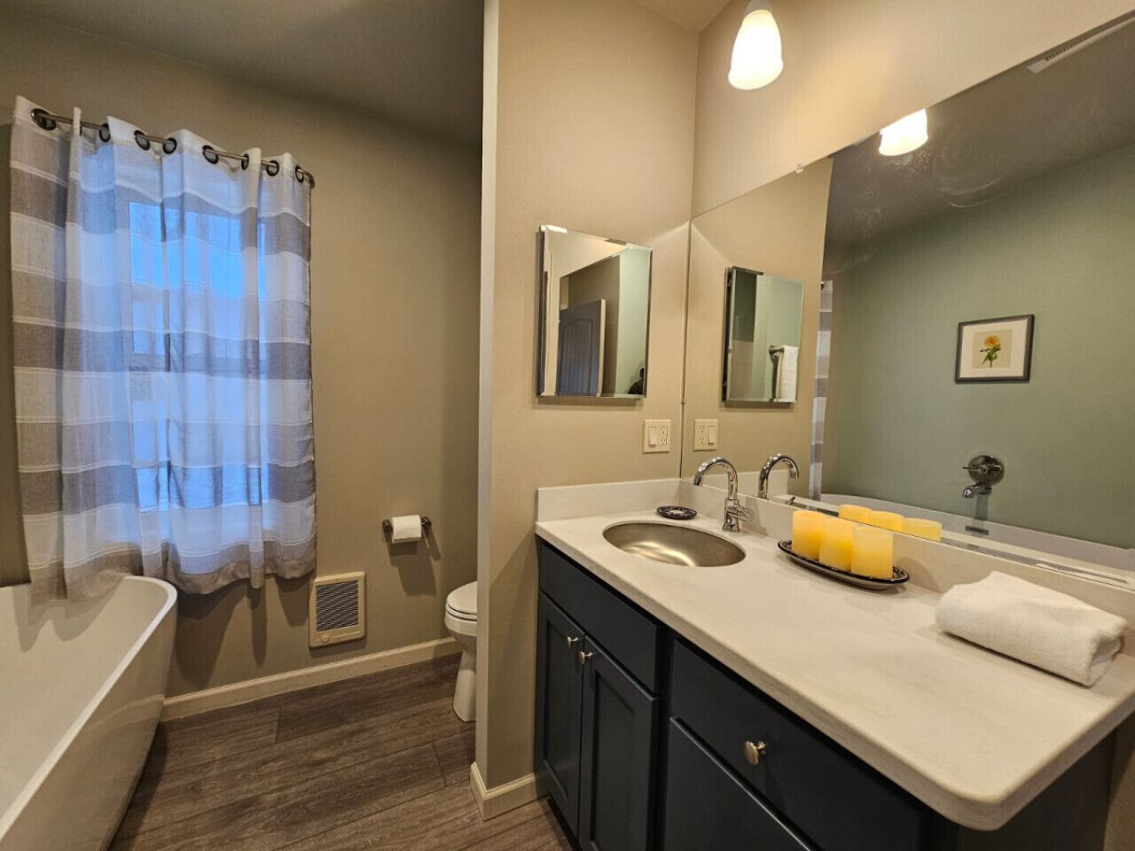 Une salle de bain avec une baignoire, un lavabo avec un miroir et des toilettes.