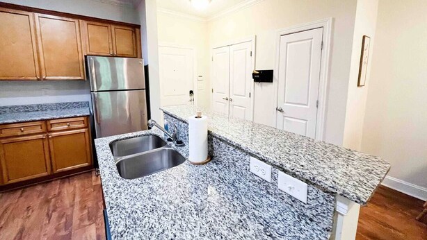 A kitchen with granite countertops, stainless steel appliances, wooden cabinets, and white walls. - Fort Mill - 14 day furnished stay or longer! (Fort Mill)