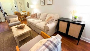 A living room with a sofa, armchairs, a coffee table, and a sideboard. - Fort Mill - 14 day furnished stay or longer! (Fort Mill)