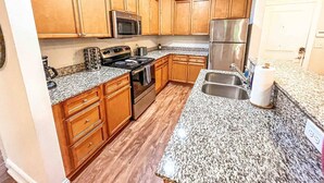A kitchen with wooden cabinets, granite countertops, stainless steel appliances, and a double sink. - Fort Mill - 14 day furnished stay or longer! (Fort Mill)