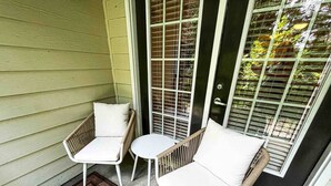 A small outdoor seating area with two chairs and a table, a doormat, and a sliding glass door. - Fort Mill - 14 day furnished stay or longer! (Fort Mill)