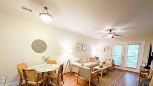 A spacious living room with a dining area, a sofa set, and a ceiling fan. - Fort Mill - 14 day furnished stay or longer! (Fort Mill)