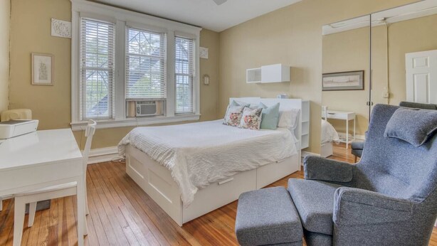 A bedroom with a bed, a desk, a chair, and a ceiling fan. - Sunny, 2 Bedroom Apt near Johns Hopkins, Charles Village - Explore Baltimore! (Maryland)
