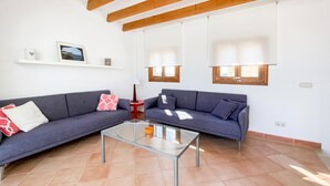 Ein Wohnzimmer mit zwei Sofas, einem Glastisch und einer Lampe.