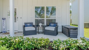 A covered porch with two wicker chairs, a small table, and a bench. - Elegant Home 4BR/2BA Minutes From 30A & Sandestin Shopping (Santa Rosa Beach)