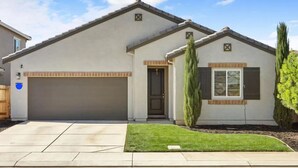 A single-story house with a garage, a front door, and a small front yard with a tree. - VIP CLASS TWO ~ Real Comfort ~ 3 Bedrooms (Lodi)