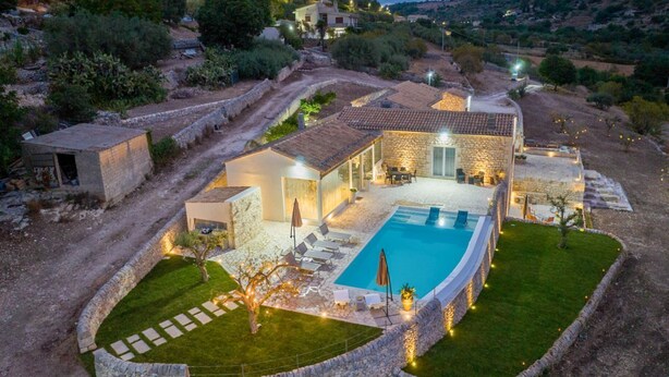 A villa with a swimming pool, stone walls, and outdoor seating. - Villa Domus Sicilia - Charming Living (Modica)