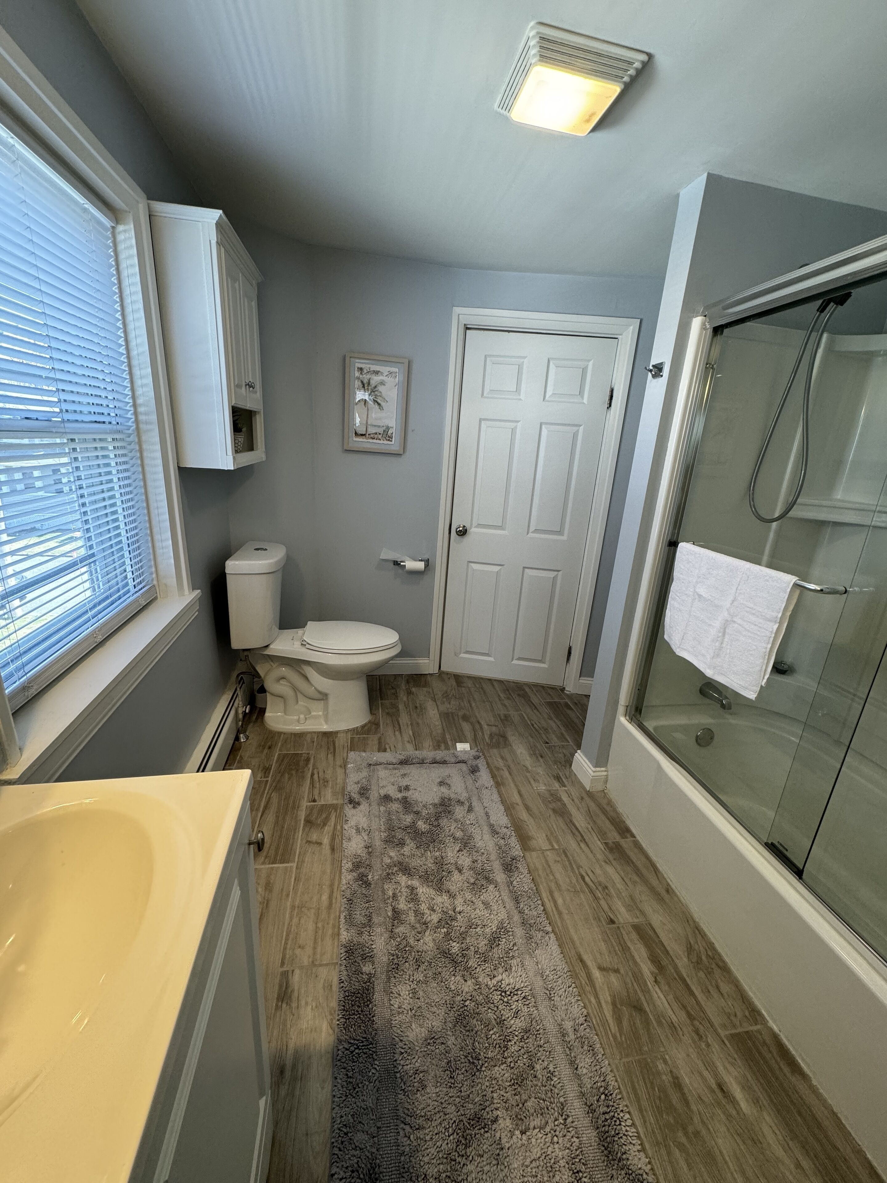 A bathroom with a toilet, sink, and shower.