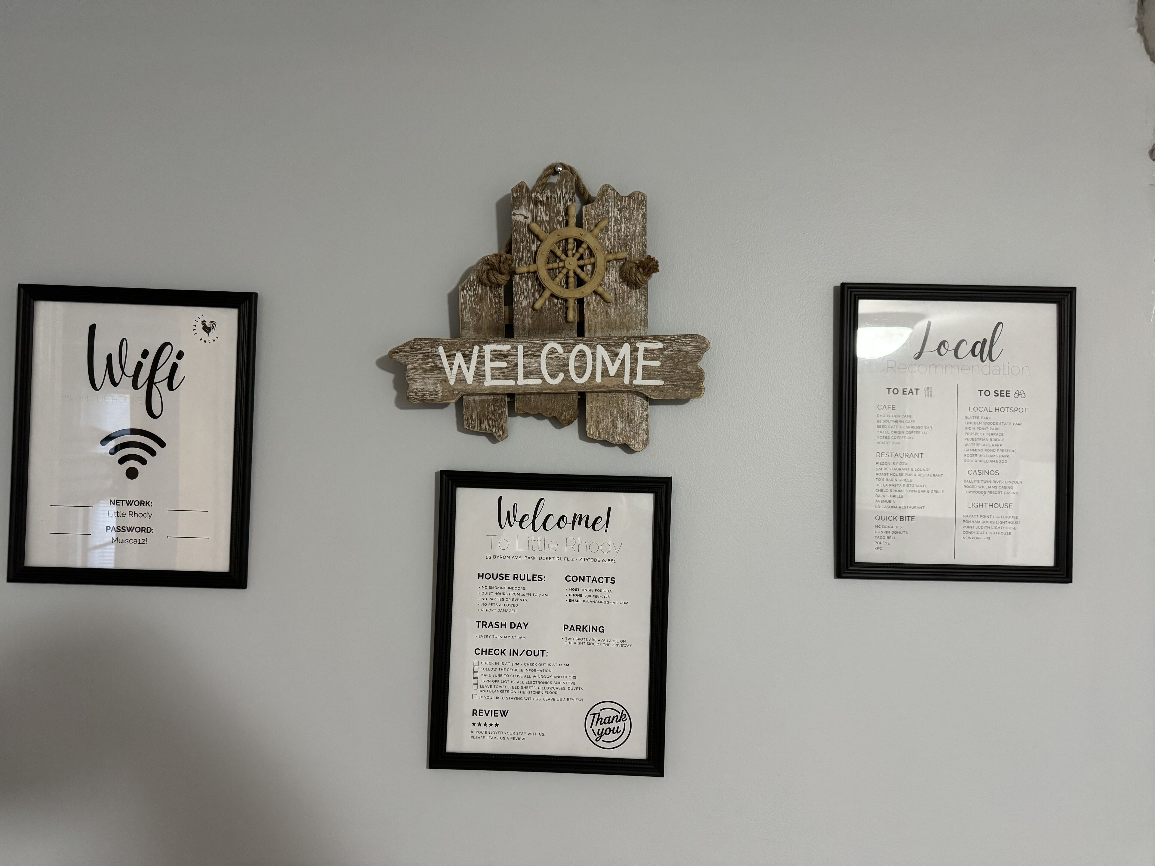 Trois panneaux encadrés accrochés au mur : « Wifi », « Bienvenue » et « Recommandations locales ».