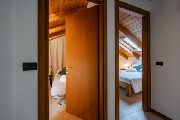 Un dormitorio con techo de madera, una cama y una mesita de noche.