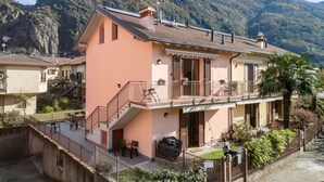 Un bâtiment à deux étages doté d’un balcon, d’un escalier et offrant une vue sur une montagne.