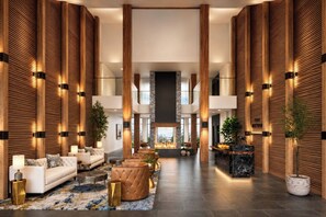 A spacious lobby with a fireplace, seating area, and wooden paneling.