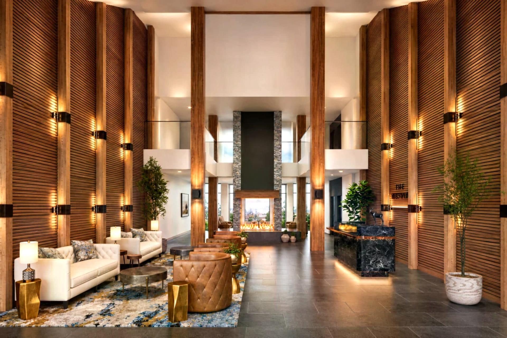 Eine geräumige Lobby mit einem zentralen Kamin, Holzvertäfelung und einer Sitzecke mit Sofas und einem Couchtisch.