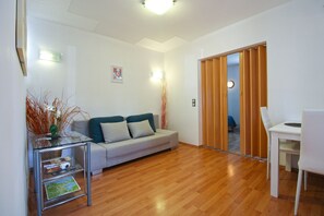 Relax in this stylish living room with a sofa, coffee table, and dining area.