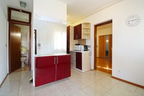 Compact kitchen with a microwave, coffee maker, and clock, offering a convenient space for meal preparation.